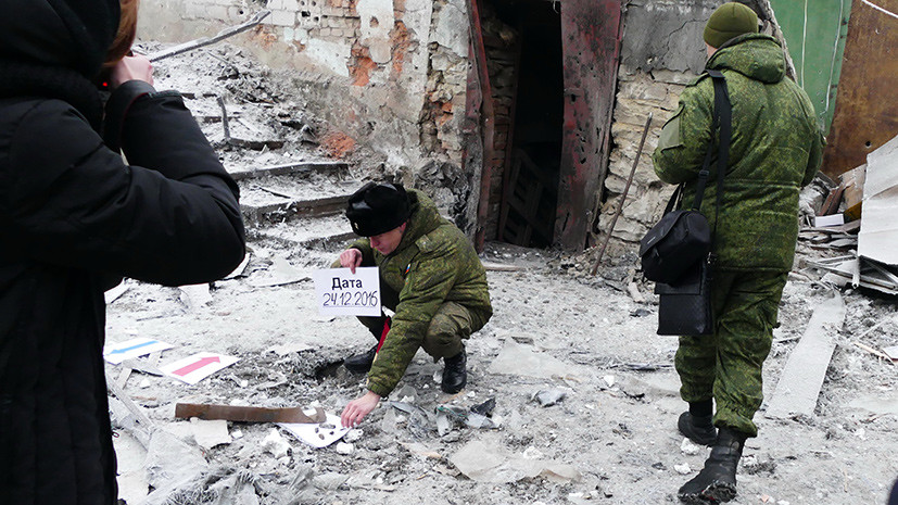 Военнослужащие осматривают разрушения после обстрела украинскими силовиками города 